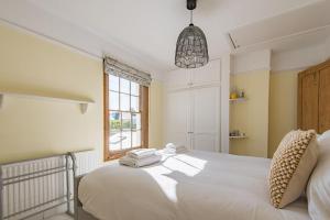 a bedroom with a white bed with towels on it at Pebble Beach Cottage by Keepers Cottages in Kingsdown