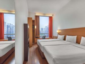 a hotel room with two beds and two windows at Ibis Singapore Novena in Singapore +45 photos