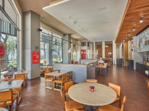 a restaurant with tables and chairs in a cafeteria at Ibis Singapore Novena in Singapore