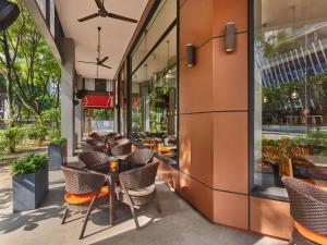 an outdoor patio with tables and chairs in a building at Ibis Singapore Novena in Singapore