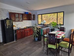 a kitchen with wooden cabinets and a table with plants at "Refugio campestre familiar - Cálido, cómodo y totalmente equipado" y zona de juegos in Nariño