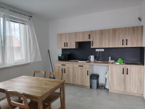 a kitchen with wooden cabinets and a table and a table and chairs at Ubytování Blažej in Týnec
