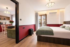 a bedroom with a large bed and a kitchen at Casa Lavanda by Blossom Hotels in Granada