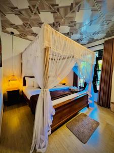 a bedroom with a bed with a canopy at LEAFORA Cottage in Galle