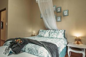 a bedroom with a bed with a teddy bear on it at Home on a Hill Accommodation in Tzaneen