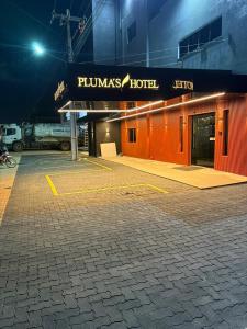 a parking lot in front of a hotel at night at Plumas hotel in Tucuma