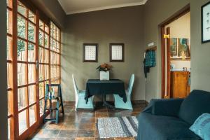 a living room with a table with chairs and a couch at Home on a Hill Accommodation in Tzaneen