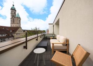 a balcony with chairs and a building with a clock tower at Limehome Braunschweig Kaiserstraße in Braunschweig