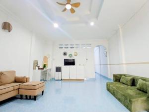a living room with two couches and a ceiling fan at Rainhill@Betong in Betong