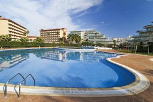 a large swimming pool with buildings in the background at Los Juncos HomeStay by Turismar in La Pineda