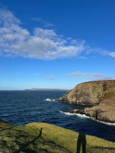 a person standing on a cliff near the ocean at Erris Ocean House in Belmullet