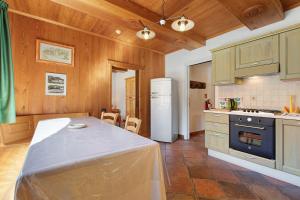 a kitchen with a table and a white refrigerator at Chez Duclos Bionaz in Bionaz