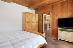 a bedroom with a bed and a flat screen tv at Chez Duclos Bionaz in Bionaz