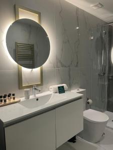 a bathroom with a sink and a toilet and a mirror at Wake Up Famalicão in Vila Nova de Famalicão +34 photos