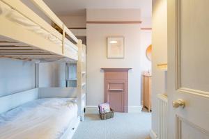 a bedroom with two bunk beds and a fireplace at Whispering Waves by Keepers Cottages in Hythe