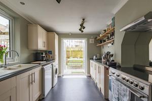 a large kitchen with white appliances and a large window at Whispering Waves by Keepers Cottages in Hythe