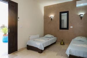 a bedroom with two beds and a window at Villa l'olivier in Djerba +29 photos