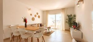 a dining room with a table and white chairs at Duplex Ancla in L'Ametlla de Mar