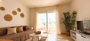 a living room with a couch and a tv at Duplex Ancla in L'Ametlla de Mar