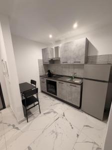 a kitchen with a sink and a refrigerator and a table at Vulcano Rooms 4 in Catania