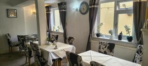 a dining room with a table and chairs and a clock at The Sands Hotel in Paignton