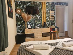 a bedroom with a bed and a dresser with a television at Chambre Mare a Mare in Porto-Vecchio