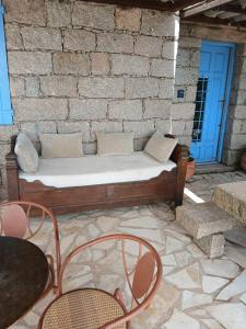 a bed sitting on a patio with a brick wall at Chambre Mare a Mare in Porto-Vecchio