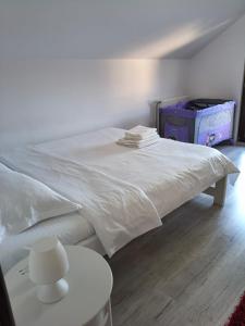 a white bed in a room with a table at Casa Roxana in Pangarati