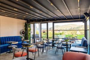 a restaurant with tables and chairs and a large window at Hotel Almar in Sarandë