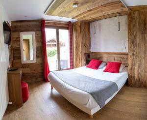 a bedroom with a large bed with red pillows at Chalet Adelphine 1 & SPA in Les Gets +13 photos