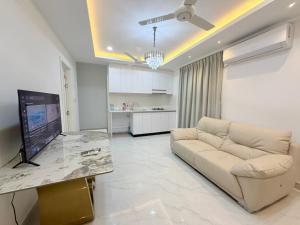 a living room with a couch and a flat screen tv at Marine Holiday in Hulhumale