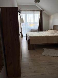 a bedroom with a bed and a large window at Vanessa Home in Floreşti