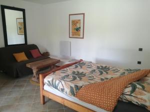 a bedroom with a bed and a couch at La ferme des Perdilles in Biran
