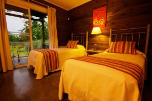 a bedroom with two beds and a window at Hotel Spa Posada del Puerto in Gualeguaychú