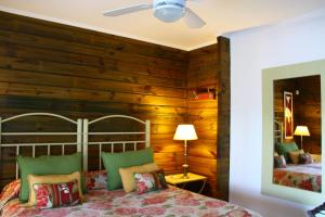 a bedroom with wooden walls and a bed with a headboard at Hotel Spa Posada del Puerto in Gualeguaychú