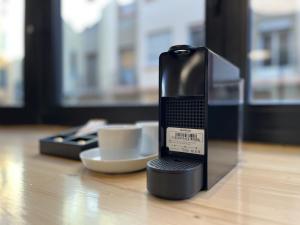 a coffee maker sitting on a table with two cups at VTZ Minimal Suites in Zaragoza