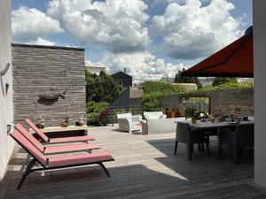 a patio with a table and chairs on a deck at Chambres d'hôtes Ty Embruns in Larmor-Plage