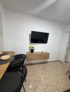 a living room with a flat screen tv on a wall at Alma azul in Puerto de Mazarrón +8 photos