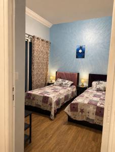 a bedroom with two beds and a blue wall at Luxury apartment Smir Park - Marina Smir in Marina Smir