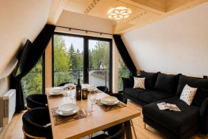 a living room with a table and a large window at Tatry Residence SPA in Kościelisko +99 photos