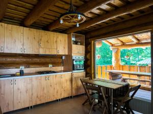 a kitchen with wooden cabinets and a table with chairs at Craiasa Draganului in Poeni