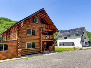 a large wooden house with solar panels on the roof at Craiasa Draganului in Poeni