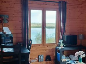 a room with a window and a desk with a computer at Skye Coorie Cabin in Breakish
