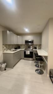 a large kitchen with white cabinets and appliances at The Urban Nest 2 in Calgary