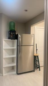 a kitchen with a stainless steel refrigerator with shelves at The Urban Nest 2 in Calgary
