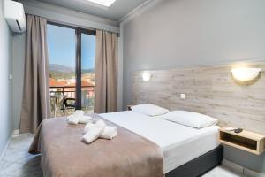 una camera da letto con un grande letto con asciugamani sopra di Meni Studios a Limenaria Altre 30 foto
