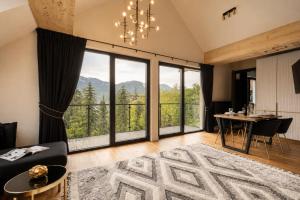 a living room with a table and a large window at Tatry Residence SPA in Kościelisko