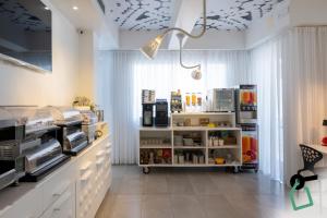 a room with a kitchen with white cabinets and a ceiling at Hotiday Porto Cesareo Laguna in Porto Cesareo