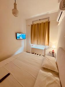 a bedroom with a large bed and a television at B&B Del Popolo in Torre Chianca
