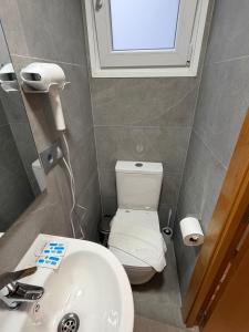 a bathroom with a toilet and a sink and a window at Hotel Ibiza in Sitges +25 photos